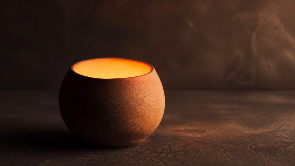 Warm light shining from a simple clay vessel, symbolising the inner quality of the heart.